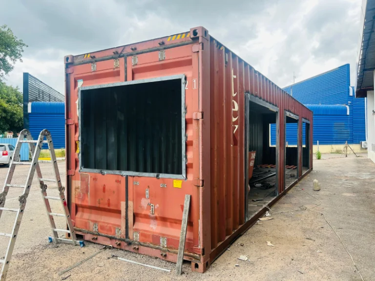 Red shipping container being converted on site
