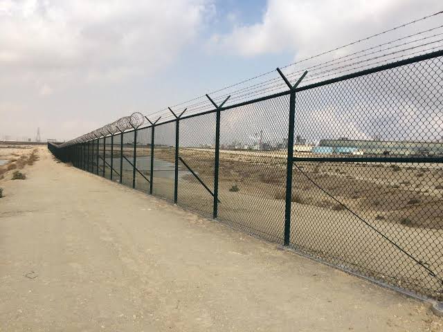 Security fence with razor wire along a boundary