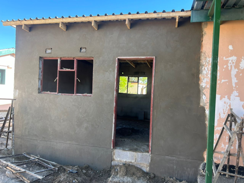 House under construction with plastered walls and scaffolding
